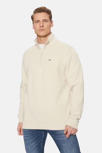 Beige ronde hals sweater van TOMMY JEANS met halve rits en klein logo op borst, gedragen met blauwe jeans, front view