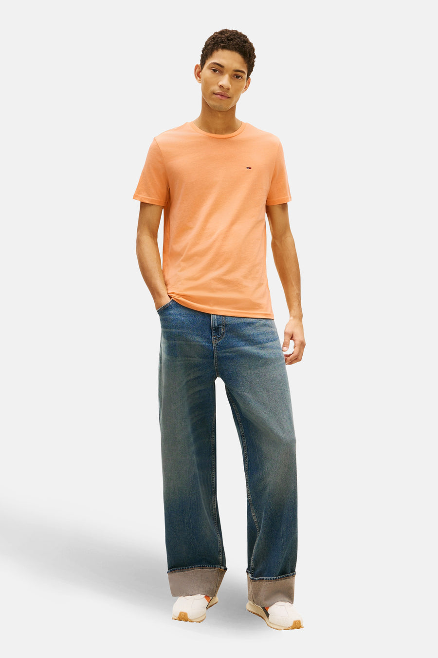 Oranje T-shirt met korte mouwen van Tommy Jeans, met een klein logo op de borst.
