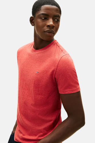 T-shirt rouge à manches courtes de TOMMY JEANS, design simple avec petit logo sur la poitrine, porté par un modèle.