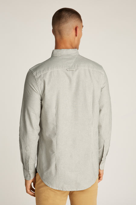 Grijs gestreept overhemd met lange mouwen van TOMMY JEANS, gezien vanaf de achterkant, met lichtbruine broek.
