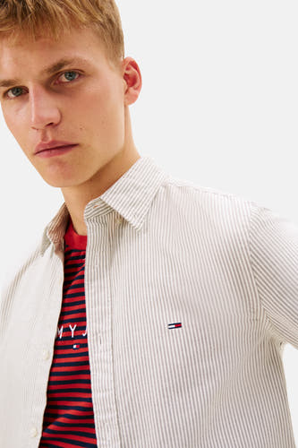 T-shirt Tommy Jeans à manches longues, rayé et avec un t-shirt rouge en dessous.