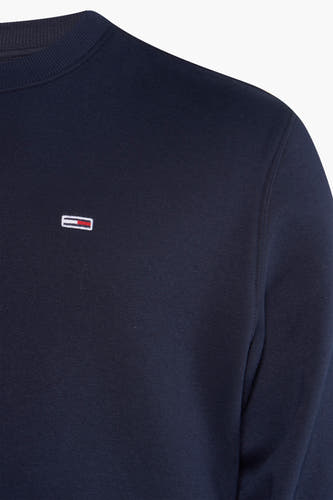 Pull-over bleu de TOMMY JEANS, avec un col rond et un petit logo sur la poitrine.