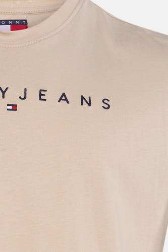 T-shirt beige à manches courtes de TOMMY JEANS, avec le nom de la marque brodé en bleu marine.