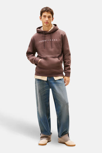 Gilet brun avec capuche de TOMMY JEANS, avec texte logo blanc et détails d'une chemise et d'un jean.