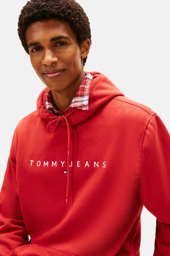 Pull-over rouge avec capuche de TOMMY JEANS, avec le nom de marque blanc sur la poitrine et un col côtelé.