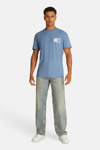 Man, blauw T-shirt, jeans, witte sneakers, staand, productfoto.
