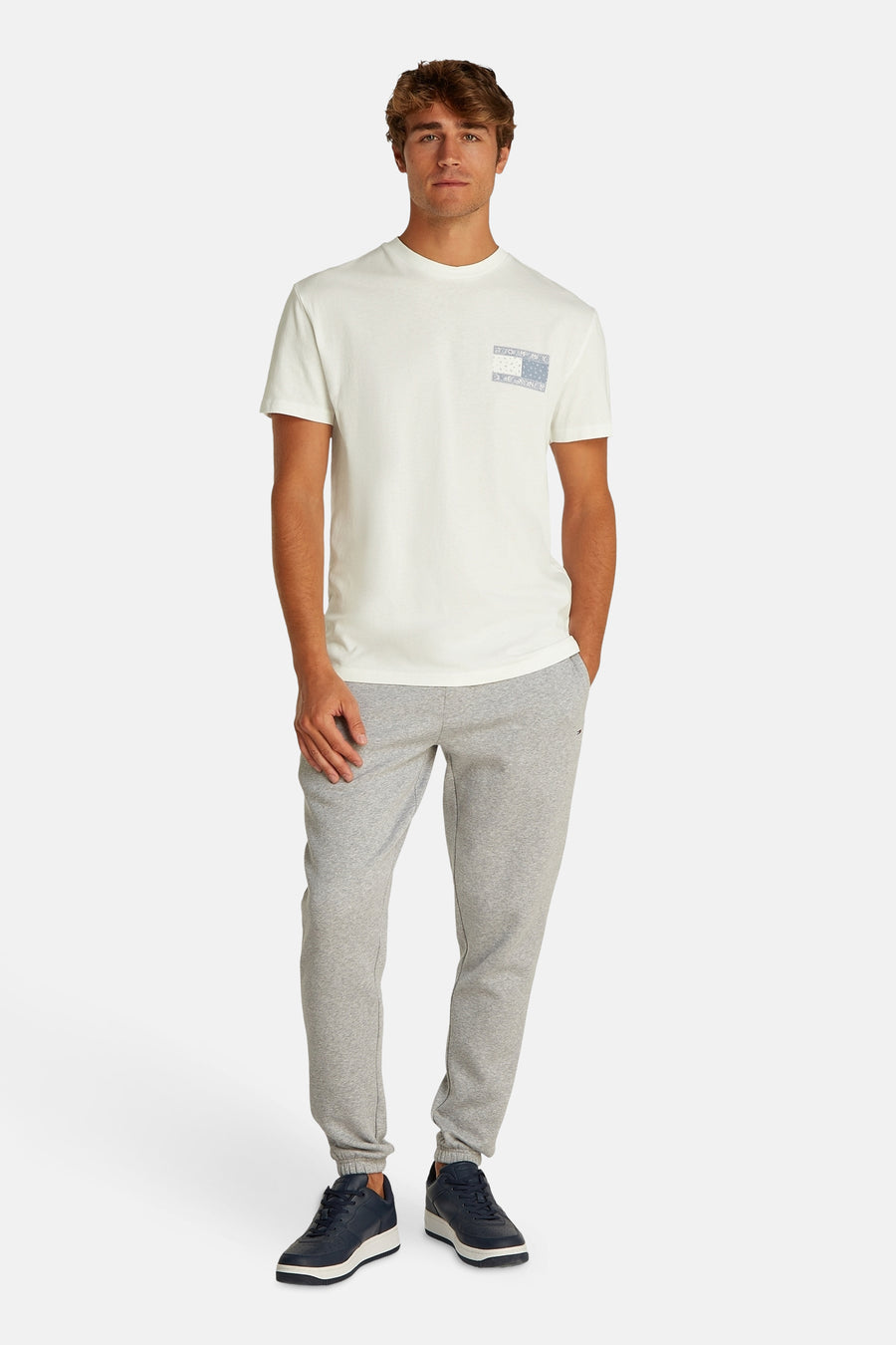 Man in wit t-shirt en grijze joggingbroek.