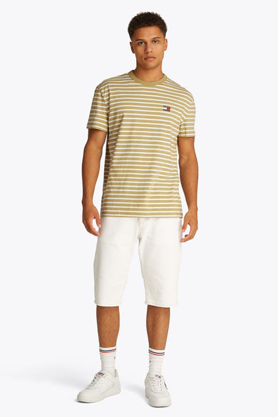 T-shirt rayé vert avec manches courtes de TOMMY JEANS, porté avec un short blanc et des baskets coordonnées avec des chaussettes.