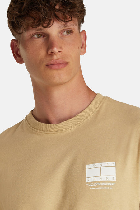T-shirt beige à manches courtes de TOMMY JEANS, avec logo sur la poitrine.