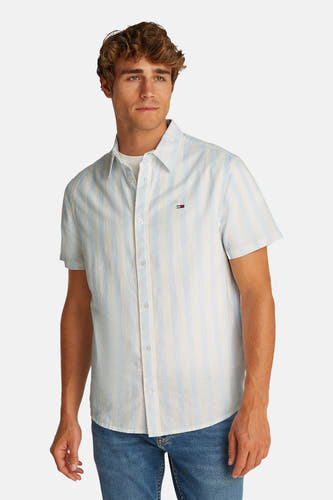 Chemise à rayures bleues avec manches courtes de TOMMY JEANS, avec col boutonné et un blason sur la poitrine.
