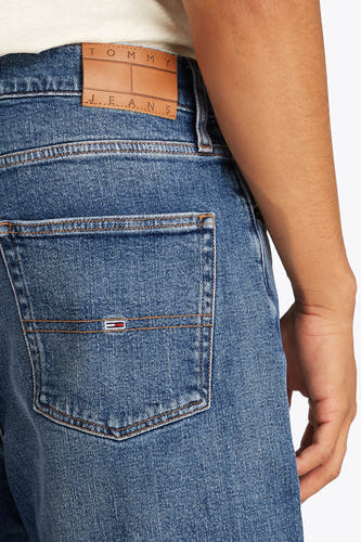 Jeansshort in middenblauw denim van TOMMY JEANS, met achterzak en bruin leren merklabel op de tailleband.