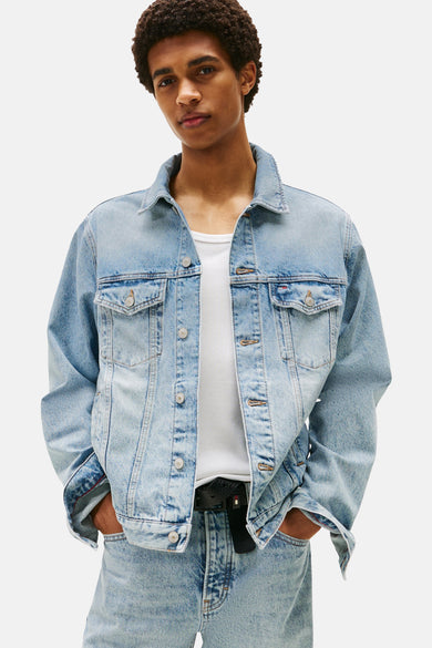 Jean de laine denim bleu clair de TOMMY JEANS, avec fermeture à boutons et poches brodées, porté sur un chemise blanche.
