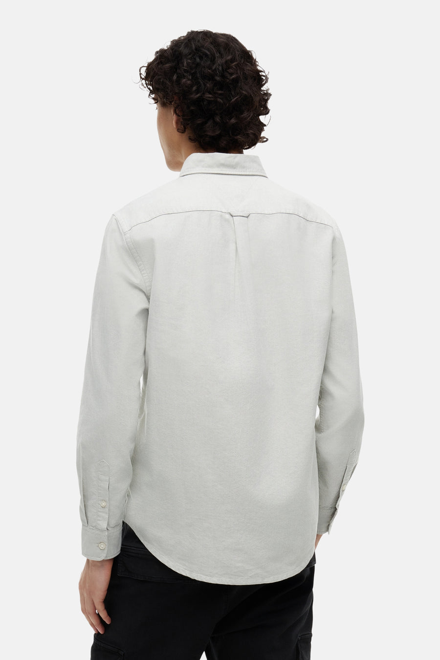 Chemise vert clair à manches longues de TOMMY JEANS, avec empiècement et pli dans le dos, portée par un homme de dos.