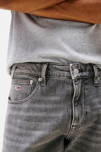 Jean slim de denim gris de TOMMY JEANS, avec un logo subtil sur la poche et une chemise gris.