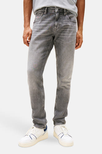 Jean slim fit gris de Tommy Jeans, avec un léger lavage et des plis subtils.