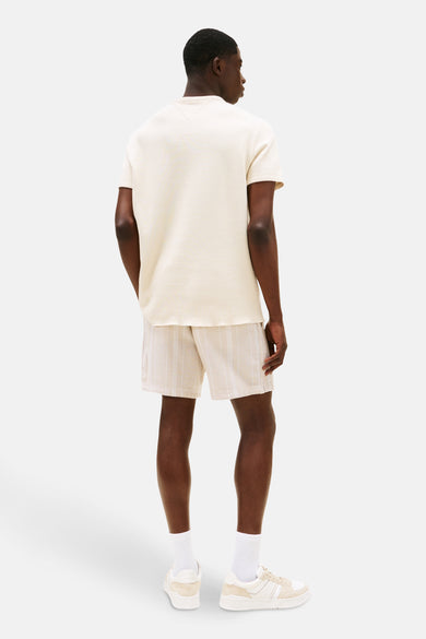T-shirt beige à manches courtes de TOMMY JEANS, avec une subtile texture et une silhouette décontractée.