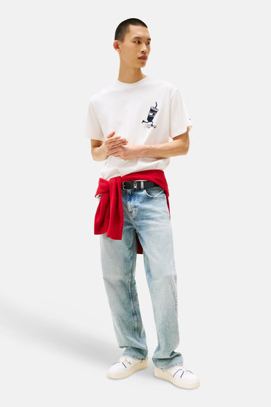 T-shirt blanc à manches courtes de TOMMY JEANS, avec un dessin, associé à une veste rouge et des jeans légers.