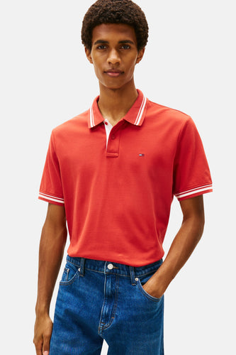 Man met rood poloshirt en blauwe jeans.