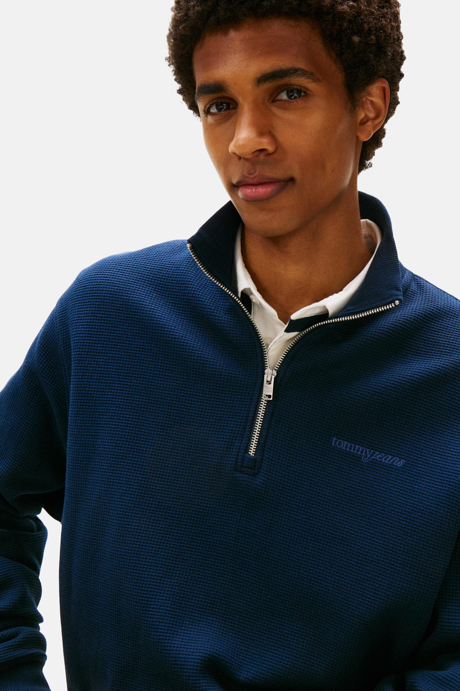 Gilet bleu de TOMMY JEANS, avec une fermeture éclair à moitié et un tissage en losange.