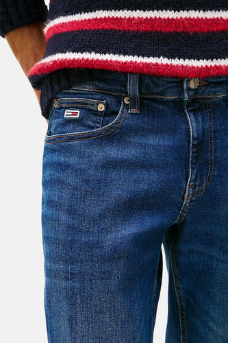 Donkerblauwe slim jeans van TOMMY JEANS, met merklogo op de zak en gestreept shirt.
