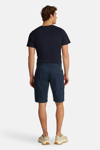Shorts bleus de TOMMY JEANS, vus de l'arrière, associés à un T-shirt bleu marine et des baskets beige.