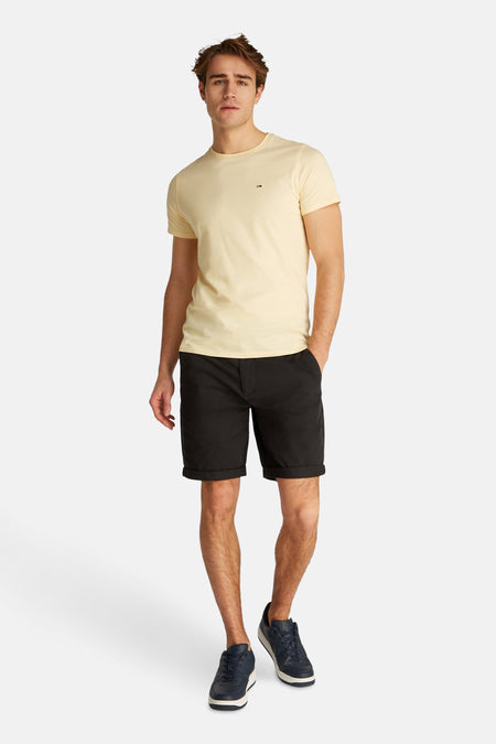 Short noir de TOMMY JEANS, associé à un t-shirt jaune et des chaussures bleues.