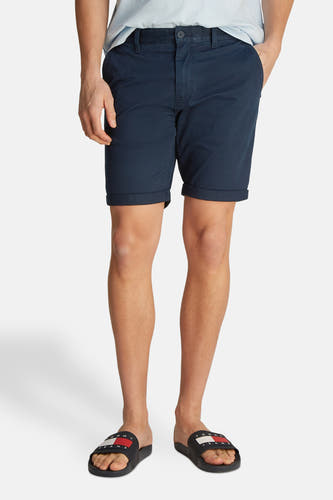Short bleu de TOMMY JEANS, avec une fermeture éclair sur le côté, porté avec des chaussures de danse.