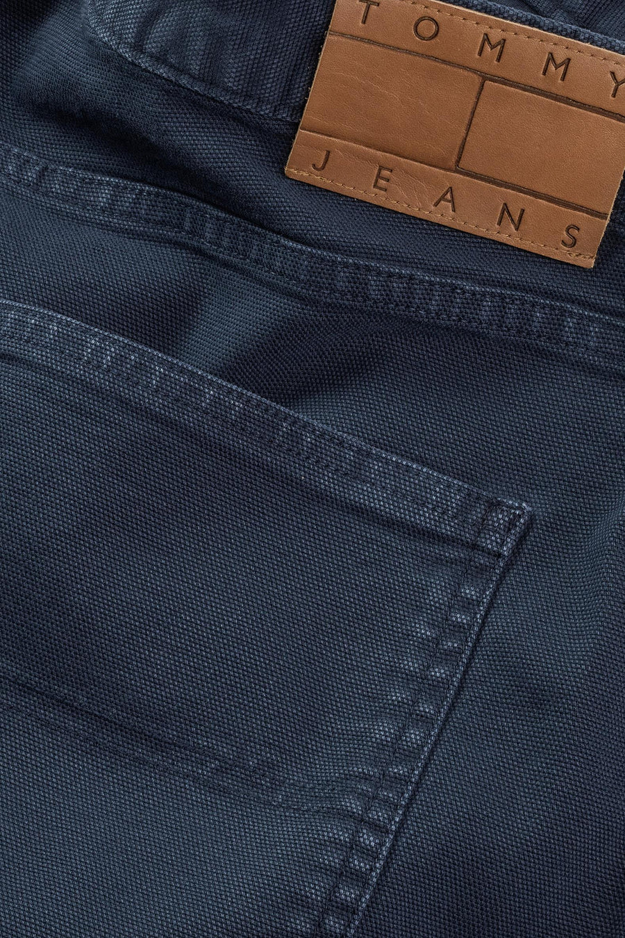 Jean court bleu de Tommy Jeans, avec logo de marque sur une étiquette en cuir.