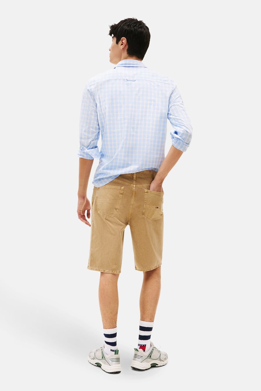 Jean court beige de TOMMY JEANS, avec poche arrière et le modèle porte une chemise bleue à carreaux.