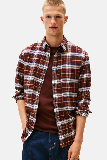 Chemise bleue longue manche de Tommy Jeans, avec un motif rayé et portée sur une chemise simple.