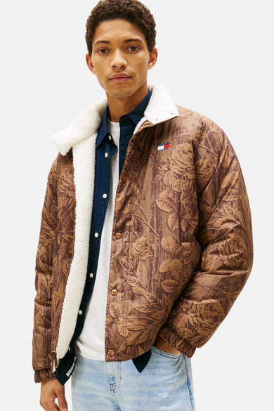 Manteau court et brun de TOMMY JEANS avec imprimé fleuri et col en fourrure synthétique, associé à une chemise et un jean.