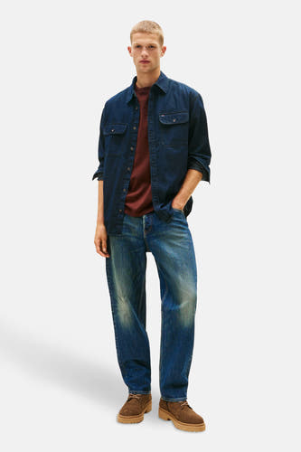 T-shirt en jeans denim denim denim denim denim de TOM TOM, portéé un un un T-shirt et et et des avec desesines.