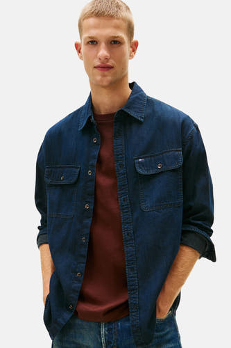 Chemise de jeans bleu marine de TOMMY JEANS, avec des manches longues et portée sur un T-shirt bordeaux, en gros plan.