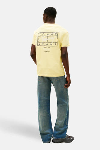 Geel T-shirt met korte mouwen van TOMMY JEANS, met print op de achterkant, gecombineerd met wijde jeans.