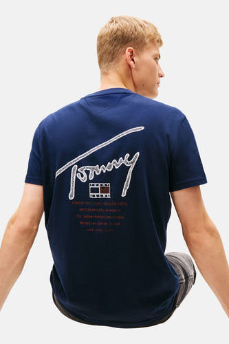 T-shirt bleu à manches courtes de Tommy Jeans, avec une impression blanche du nom de la marque sur le dos.