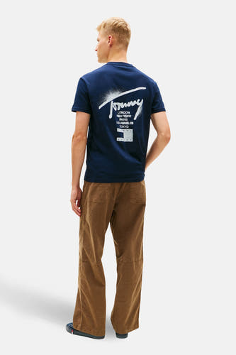 T-shirt bleu à manches courtes de TOMMY JEANS, avec imprimé de villes et pantalon marron.