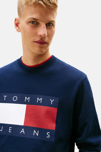 Man in een blauwe Tommy Jeans sweater.