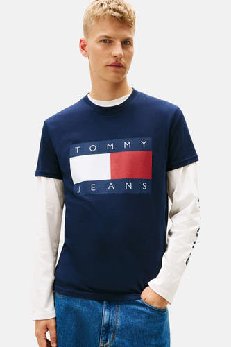 T-shirt bleu à manches courtes de TOMMY JEANS, porté avec des jeans larges et des baskets.