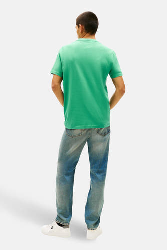 T-shirt vert à manches courtes Tommy Jeans, vu de dos, porté avec un jean et des baskets blanches.
