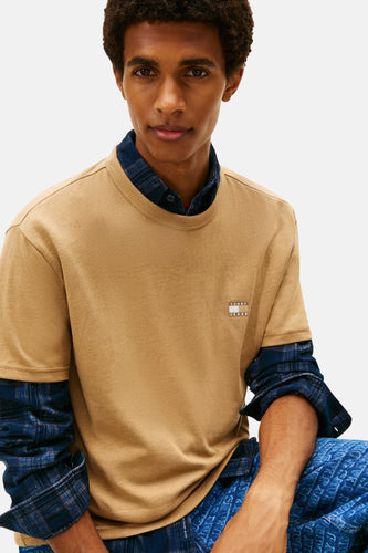 Man in bruin T-shirt en blauw overhemd.