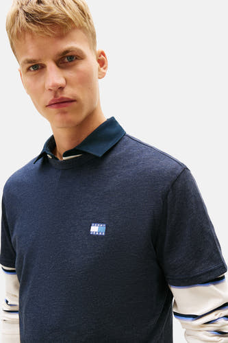 T-shirt bleu avec manches courtes de TOMMY JEANS, avec un col bleu marine et un logo subtil sur la poitrine.