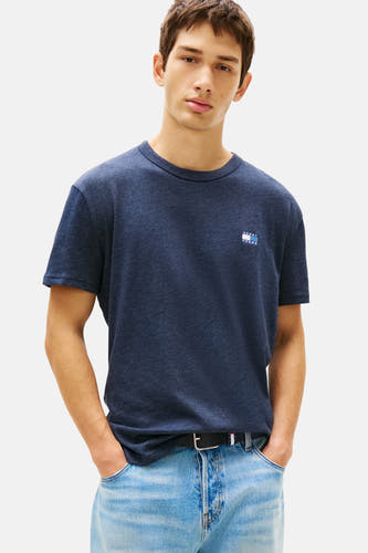 T-shirt bleu à manches courtes de TOMMY JEANS, tissu uni avec logo sur la poitrine, associé à des jeans et une ceinture.