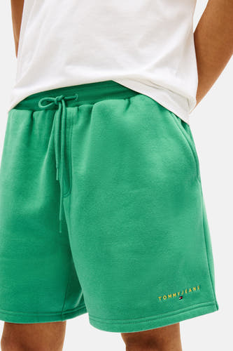 Short vert de TOMMY JEANS, avec cordon de serrage et inscription du logo sur la jambe.