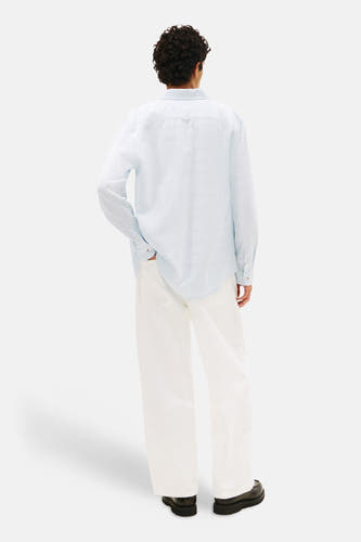 Chemise bleue TOMMY JEANS, vue de dos, à manches longues et pantalon blanc.