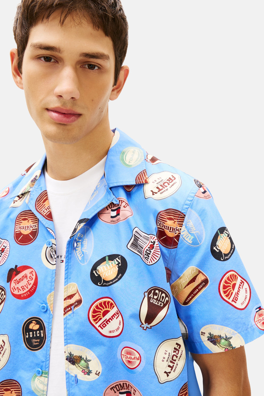 Chemise bleue à manches courtes Tommy Jeans, avec un motif d'étiquettes de fruits et de logo.