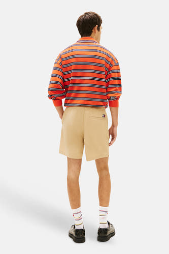 Short marron TOMMY JEANS avec texture côtelée et logo, porté par un mannequin avec une chemise rayée et des mocassins, vue arrière.