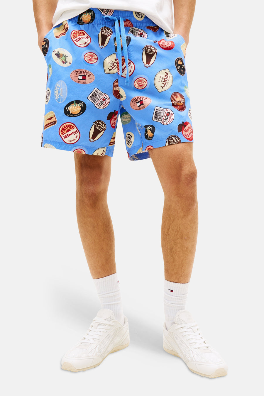 Short bleu à imprimé de Tommy Jeans, porté avec un t-shirt blanc et des baskets blanches.