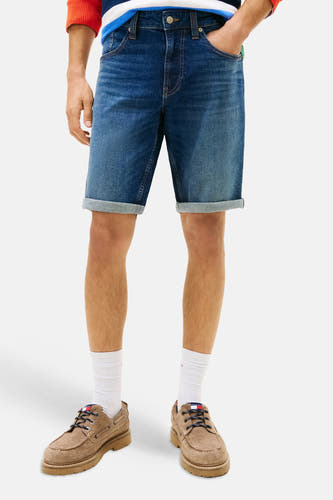 Short en jean en denim bleu marine de TOMMY JEANS avec ourlets retroussés, porté par un homme.