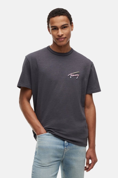 T-shirt gris à manches courtes de TOMMY JEANS, avec logo script coloré et texture subtile sur la poitrine.