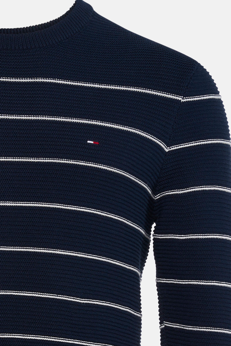 Donkerblauwe ronde hals trui met witte strepen van TOMMY JEANS, ribstructuur, detail op borst, close-up voorzijde